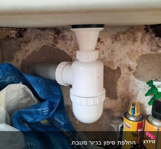 צינור ניקוז לבן מתחת לכיור עם חיבורים